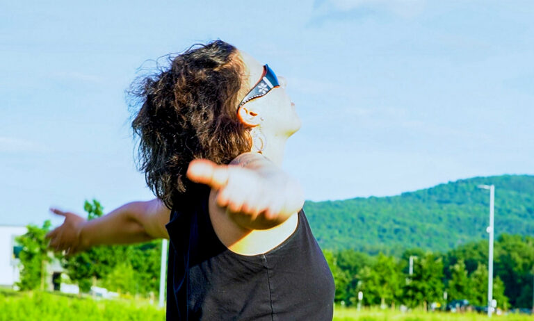 A person is stretching their arms and looking at the sky.